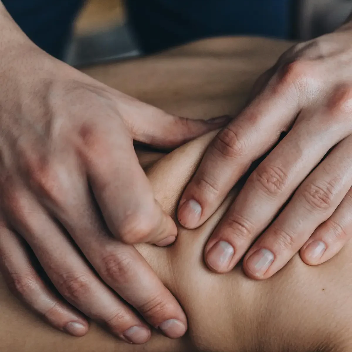 Manos del fisioterapeuta tratando a paciente en camilla